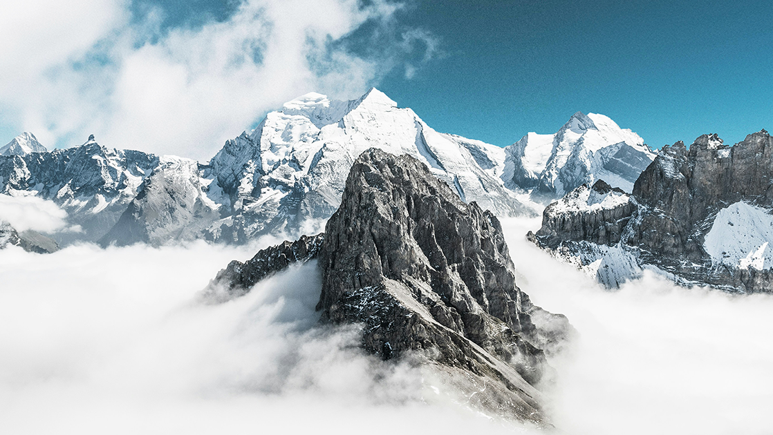 Photo of snow-covered mountain peaks in a sea of clouds (Photo)