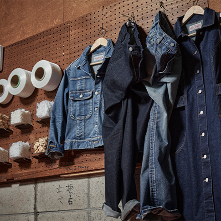 Denim jackets and trousers hanging on a wooden wall (Photo)