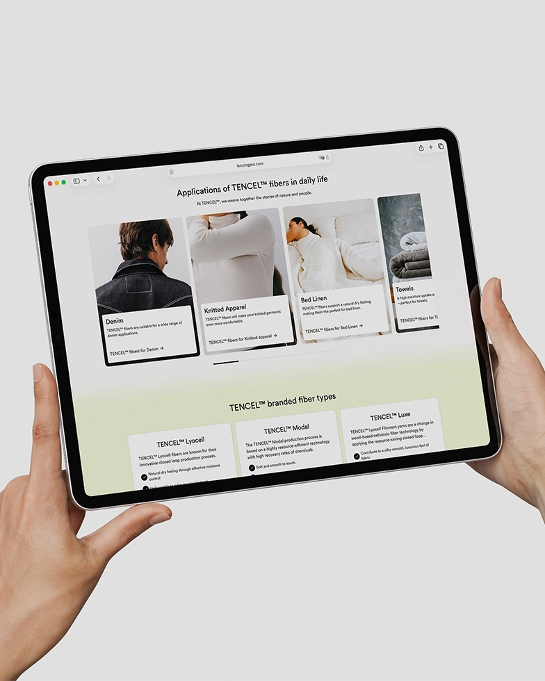 Zwei Hände halten ein Tablet mit geöffneter Webseite von Lenzing (Foto)