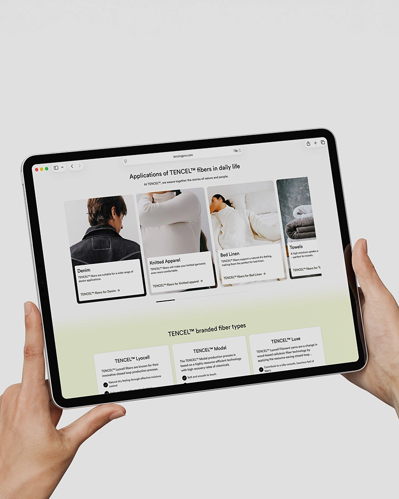 Zwei Hände halten ein Tablet mit geöffneter Webseite von Lenzing (Foto)